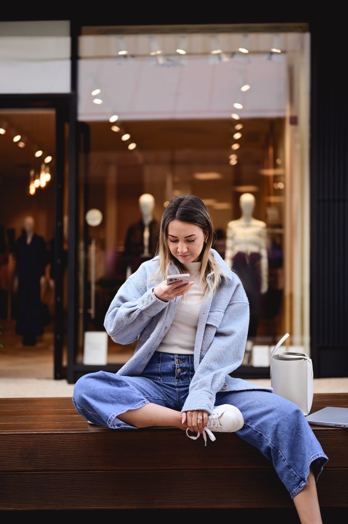 Young woman looking at her mobile phone in a shopping mall.